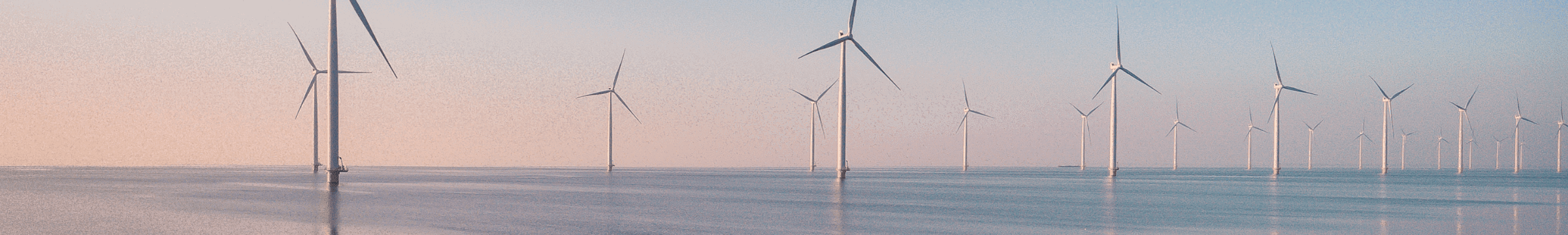 Aerogeneradores sobre el mar en un amanecer