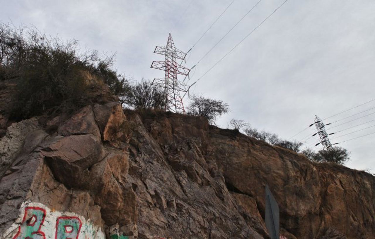 Vista de una quebrada con torre de alta tension de fondo