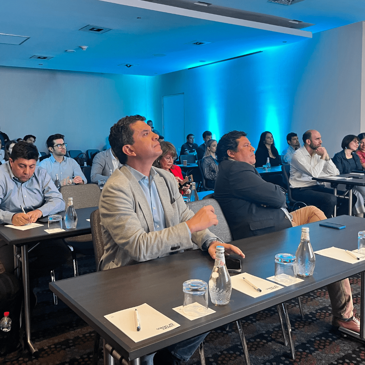 grupo de ejecutivos sentados escuchando al expositor