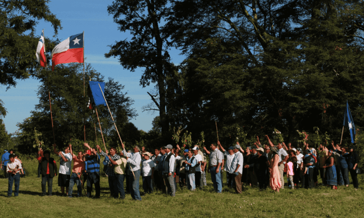 personas reunidas con bandera chilena