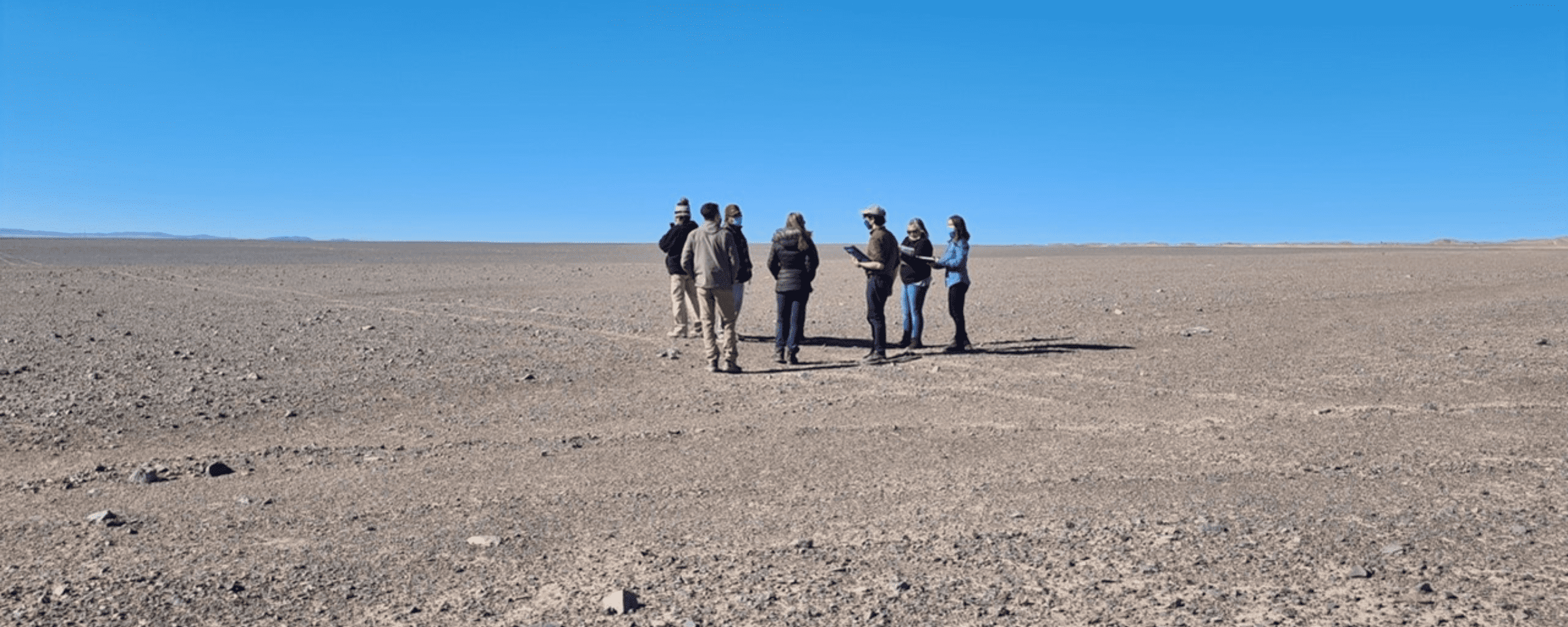 Grupo de personas en visita a terreno donde estará una planta solar